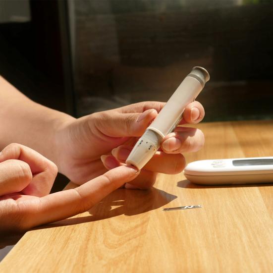 en diabetiker stikker sig i fingereren for at aflæse blodsukker