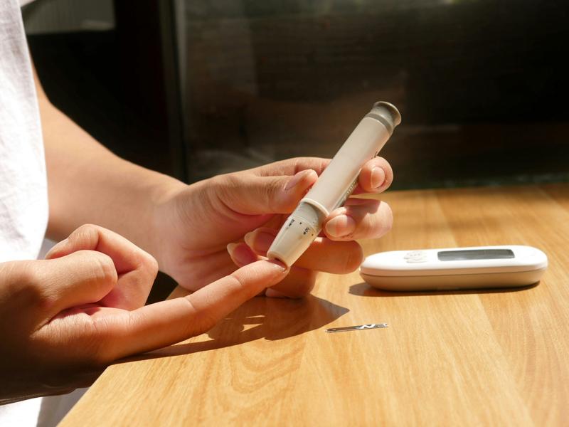 en diabetiker stikker sig i fingereren for at aflæse blodsukker