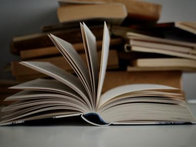 En stak bøger og foran den en opslået bog