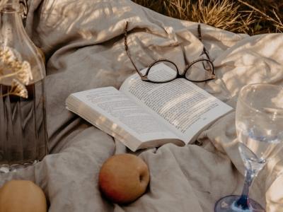 En opslået bog på et tæppe i det fri