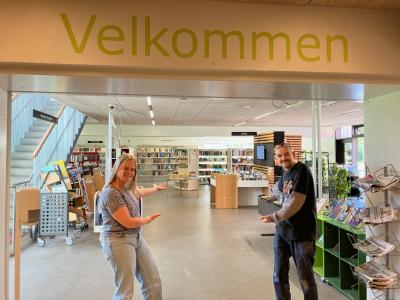 To bibliotekarer byder velkommen i Hasle Biblioteks indgangsparti