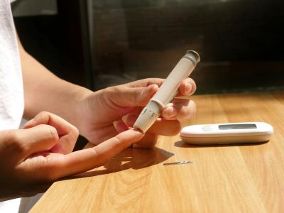 en diabetiker stikker sig i fingereren for at aflæse blodsukker