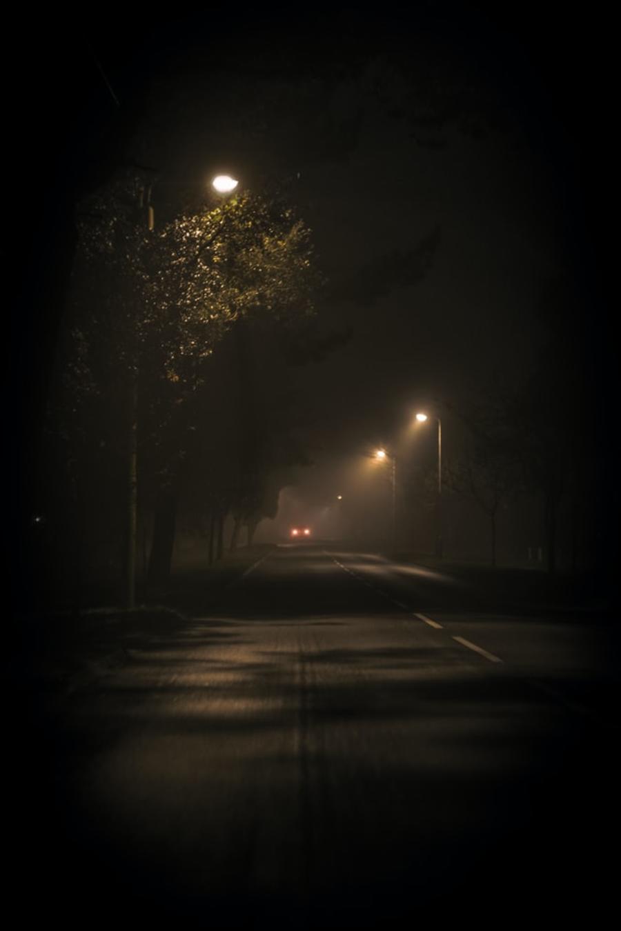 Mørk gade med enkelte gadelamper