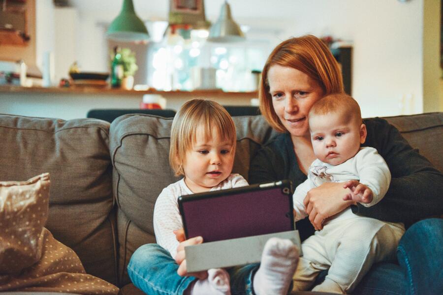 En mor læser højt fra en e-bog for 2 børn