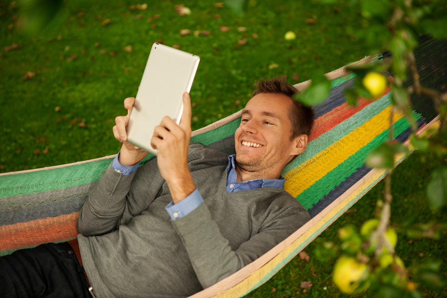 Mand der ligger og læser en e-bog