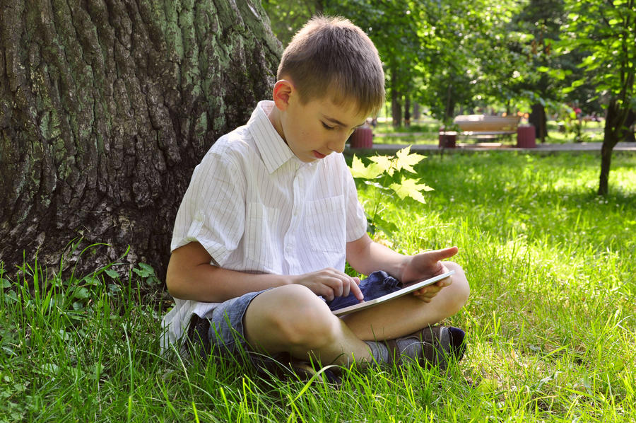 Dreng der læser på tablet