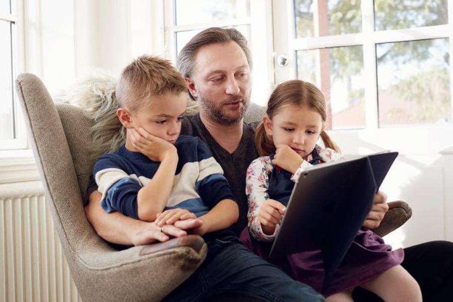 Far der læser en e-bog højt for to børn 
