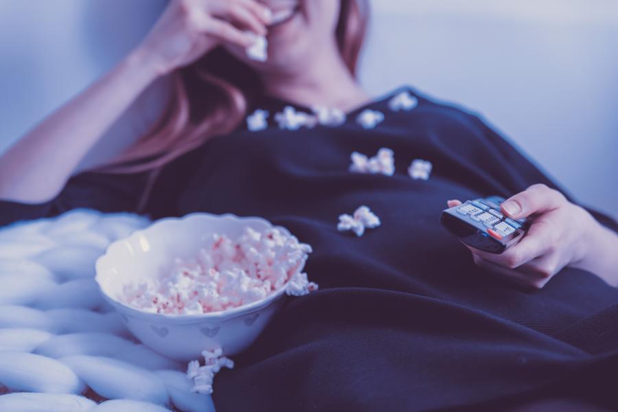 Kvinde der spiser popcorn og ser film