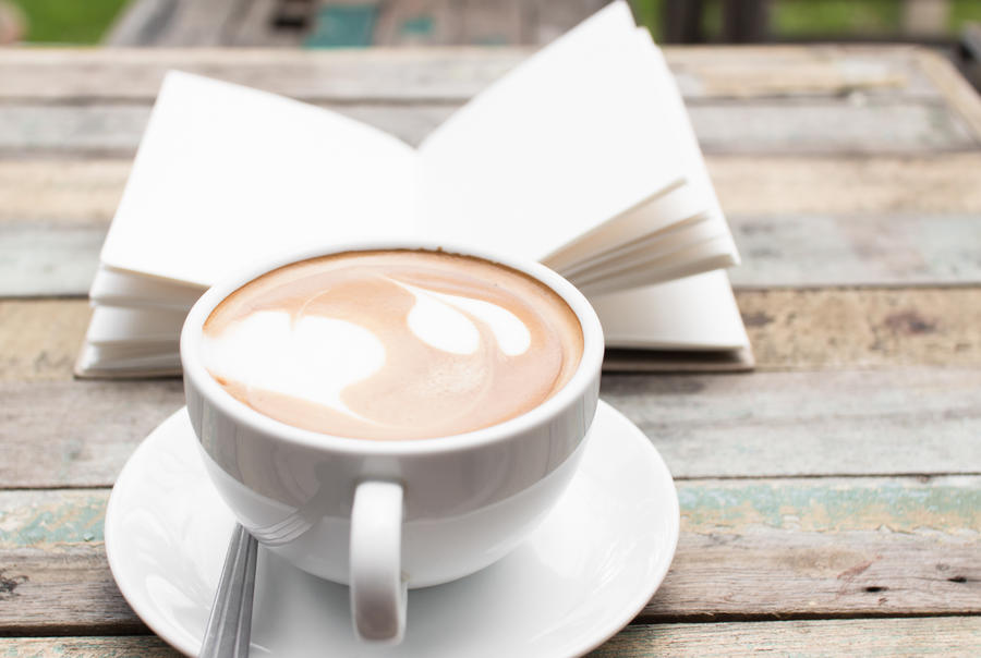 En bog og en kop kaffe på et bord