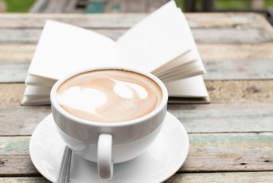 Et bord med en bog og e kop kaffe