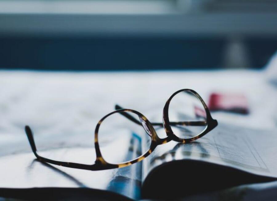 Briller der ligger på en opslået bog