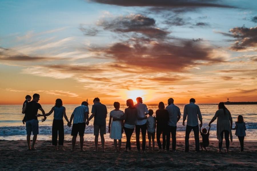 Stor familie er samlet til solnedgang på stranden